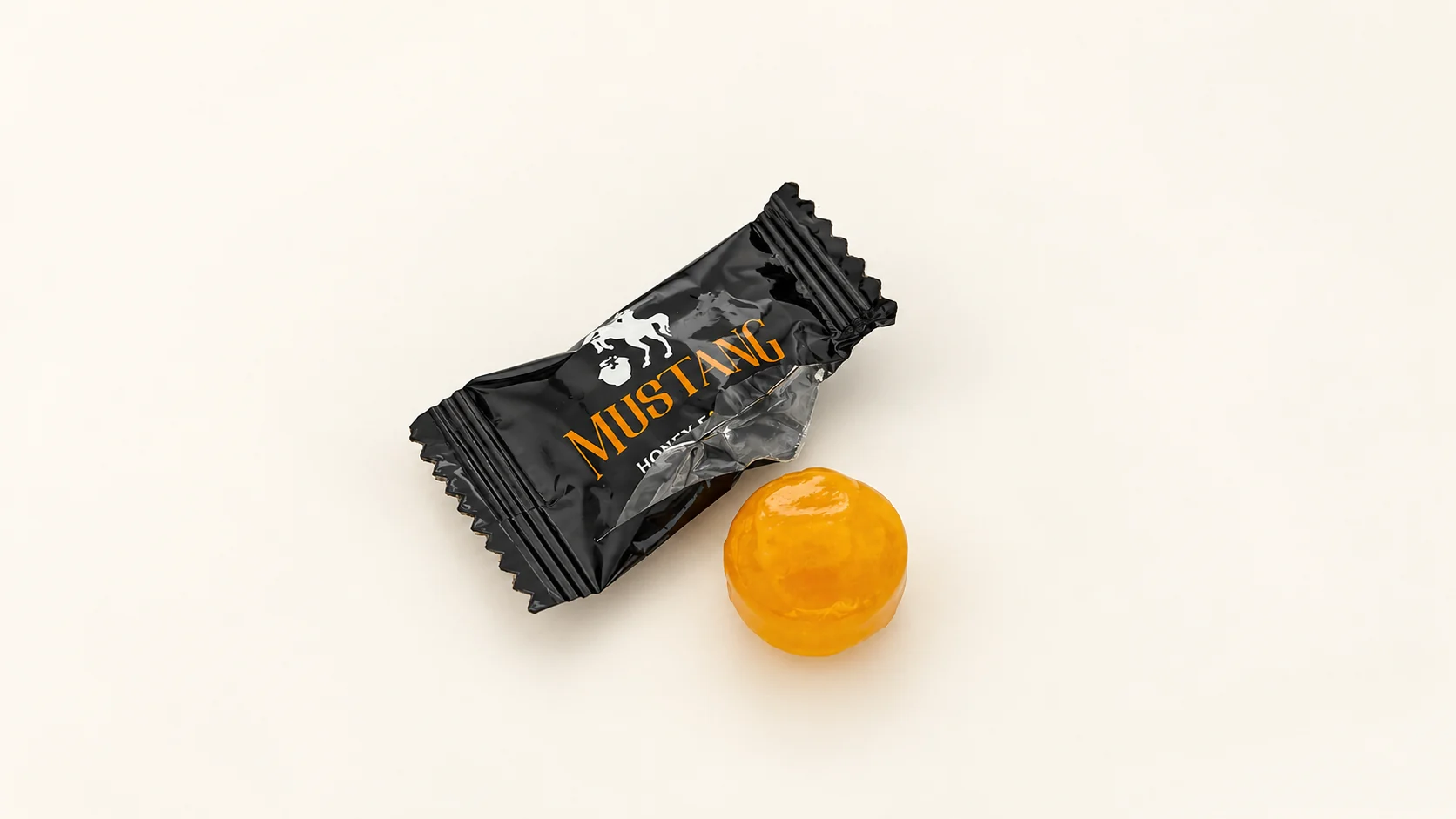 MUSTANG野馬糖開箱:從盒裝到獨立包裝,看懂實拍細節 一包黑色MUSTANG糖果包裝及一顆琥珀色糖體